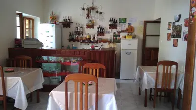 a kitchen with two tables and a kitchen with a refrigerator at Residencial Vitoria in Ponta do Sol