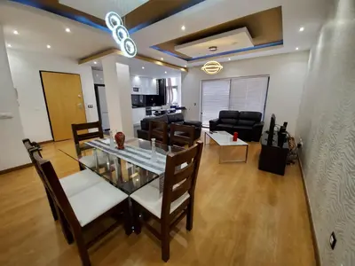 a dining room and living room with a table and chairs at Apto Duarte T2 in Praia