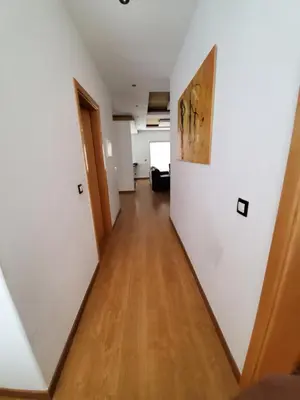 a hallway in an apartment with white walls and wooden floors at Apto Duarte T2 in Praia