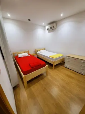 a room with two beds and a dresser in it at Apto Duarte T2 in Praia