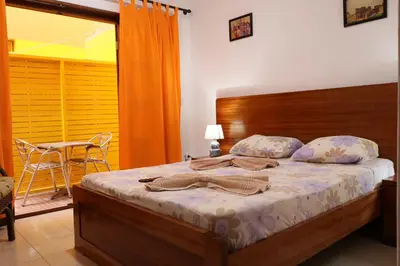 a bedroom with a bed and a table and a chair at O Jardim do Vinho, AC in Praia