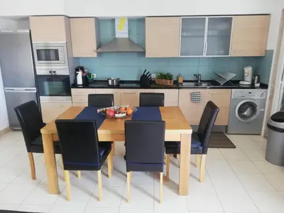 a kitchen with a wooden dining table and chairs at Apartment in Vila Verde - Pool view - Santa Maria in Santa Maria