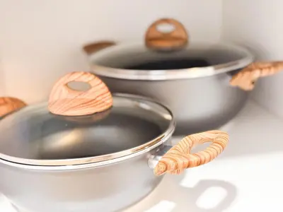 two metal pots with wooden utensils on a table at BIA D'Olaf Apartments in Santa Maria