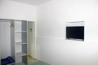 a living room with a tv on a wall at Residence A Paz in Boa Ventura