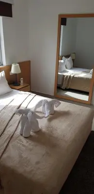 a bedroom with a large mirror on the bed at Apartamentos DECOR in Tarrafal
