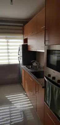 a kitchen with wooden cabinets and a microwave at Apartamentos DECOR in Tarrafal