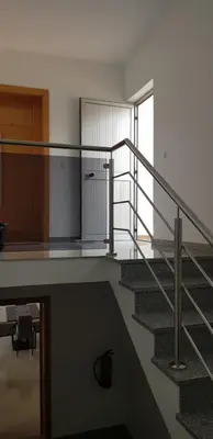 a staircase in a building with a glass railing at Apartamentos DECOR in Tarrafal