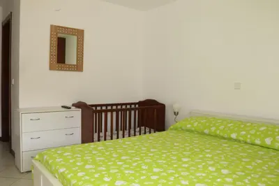 a bedroom with a bed and a dresser and a mirror at Complexo Multiuso Copacabana in Mindelo