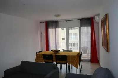 a dining room with a table and chairs and a window at Complexo Multiuso Copacabana in Mindelo