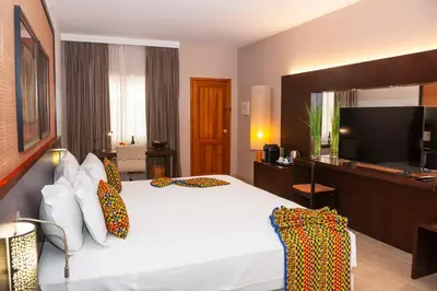 a hotel room with a bed and a flat screen tv at Pestana Tropico Ocean & City Hotel in Praia
