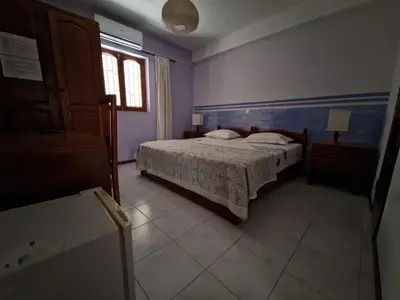 a bedroom with a bed and a window at Residencial Raiar in Mindelo