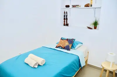 a bedroom with a blue bed with towels on it at Casa Sodadi in Praia