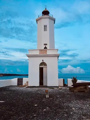 a dog standing in front of a lighthouse at Casa Sodadi in Praia