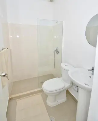 a white bathroom with a toilet and a sink at Casa Sodadi in Praia