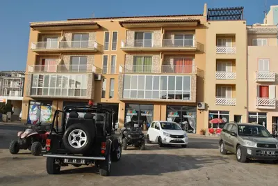 a building with cars parked in a parking lot at Special Price long term in Sal Rei
