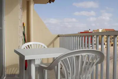 a white table and chairs on a balcony at Special Price long term in Sal Rei