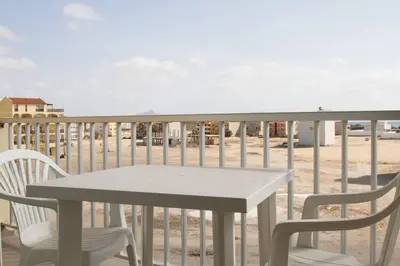 a table and chairs on a balcony with the beach at Special Price long term in Sal Rei
