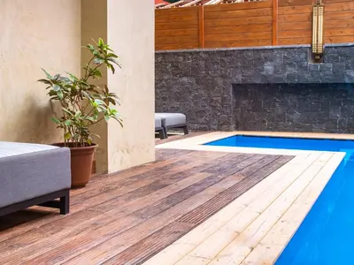 a swimming pool with a wood floor and a fireplace at Angulo House in Santa Maria