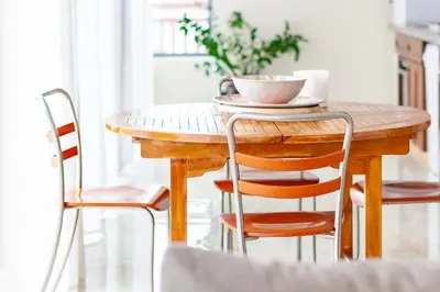 a wooden table with chairs and a cup of coffee on it at Angulo House in Santa Maria