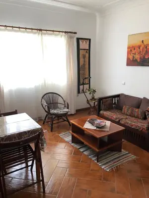 a living room with a couch and a table at Charming 2BR with Refreshing Ocean View in Praia