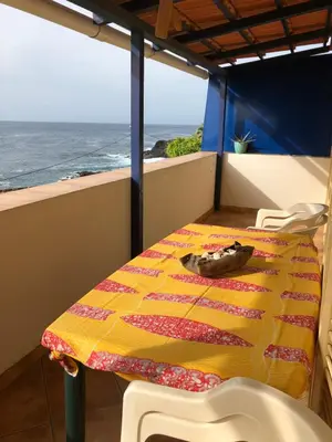 a table and chairs on a balcony with the ocean at XXL Apt w/ Surprising Gorgeous Ocean View in Praia