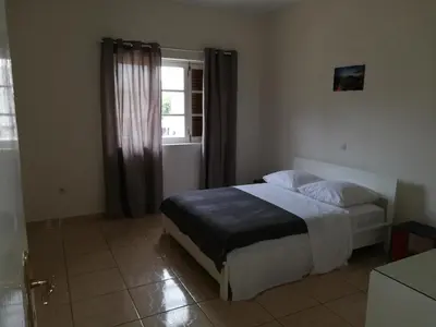 a bedroom with a bed and a window at Résidence Yô in Mindelo