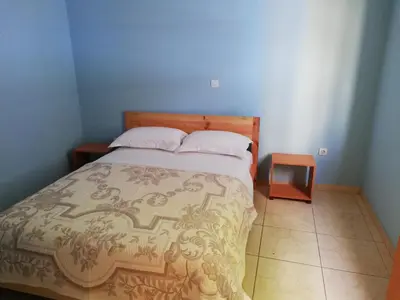 a bedroom with a bed and a nightstand next to it at Résidence Yô in Mindelo
