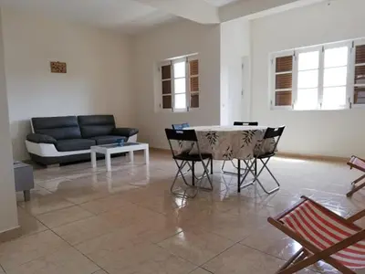 a living room with a couch and a table and chairs at Résidence Yô in Mindelo