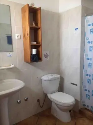 a small bathroom with a toilet and a sink at Couple Getaway with Panoramic Ocean View in Praia