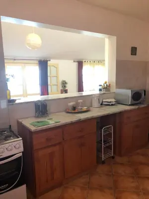 a kitchen with wooden cabinets and a counter top at Couple Getaway with Panoramic Ocean View in Praia