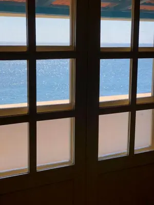 a view of the ocean through three windows at Couple Getaway with Panoramic Ocean View in Praia