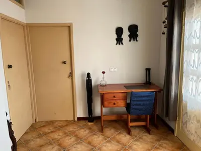 a room with a desk and a chair and a door at Splendid Guest Suite with Separate Private Ocean View Terrace in Praia