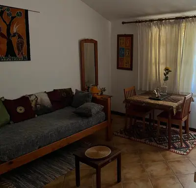 a living room with a couch and a table at Splendid Guest Suite with Separate Private Ocean View Terrace in Praia