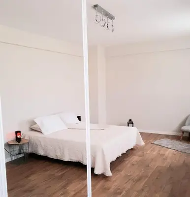 a white bedroom with a bed and a mirror at Apartment with pool in Mindelo in Mindelo