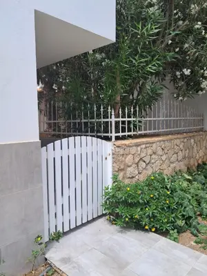 a white fence next to a stone wall at Vivenda Ronnie in Beirona