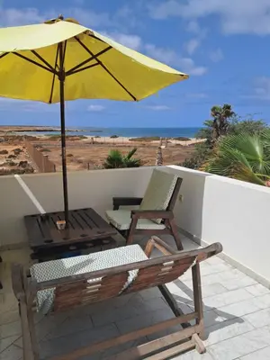 a patio with an umbrella and two chairs and a table at Vivenda Ronnie in Beirona