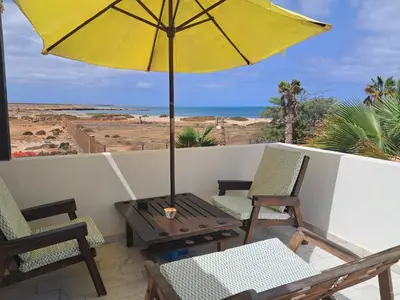 a patio with chairs and an umbrella and a table at Vivenda Ronnie in Beirona