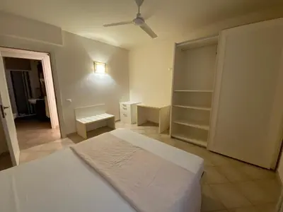 a white bedroom with a bed and a fan at Zen House Tropical in Santa Maria