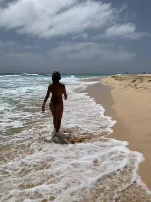 a woman walking in the water on the beach at Paradise Cape Verde in Santa Maria