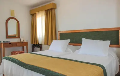 a bedroom with a bed with white sheets and a mirror at Mister Barracuda in Santa Maria
