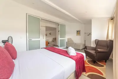 a bedroom with a large white bed and two chairs at A Casa da Mizi in Praia