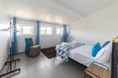 a bedroom with a bed and a chair at A Casa da Mizi in Praia