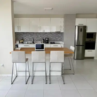a kitchen with a table with chairs and a laptop on it at Ocean View Stay in Mindelo