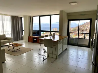 a kitchen and living room with a view of a city at Ocean View Stay in Mindelo