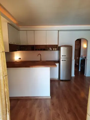 a kitchen with white cabinets and a refrigerator at Porto Antigo 2 Beach Club in Santa Maria