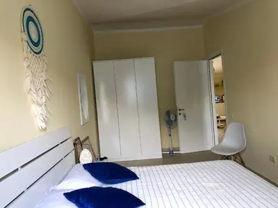 a bedroom with a bed with two blue pillows at More then a beautiful apart The real Morabeza Capeverdean hospitality in Santa Maria