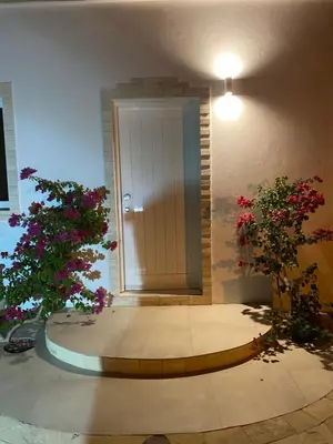 a door in a room with two trees and flowers at Villa Alfredo Marchetti Nº13 A Suites on the Beach, Praia de Chaves, Boa Vista in Cabeçadas