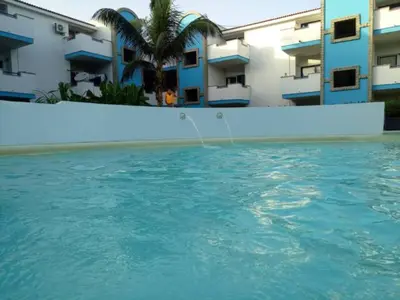 a swimming pool in front of some buildings at Apartamento Moradias Djadsal C01 próximo à Praia de Santa Maria in Espargos