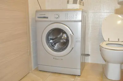 a washing machine in a bathroom next to a toilet at Apartamento Moradias Djadsal C01 próximo à Praia de Santa Maria in Espargos