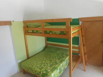 a bunk bed in a room with a green wall at Pousada do Ceu in Paul